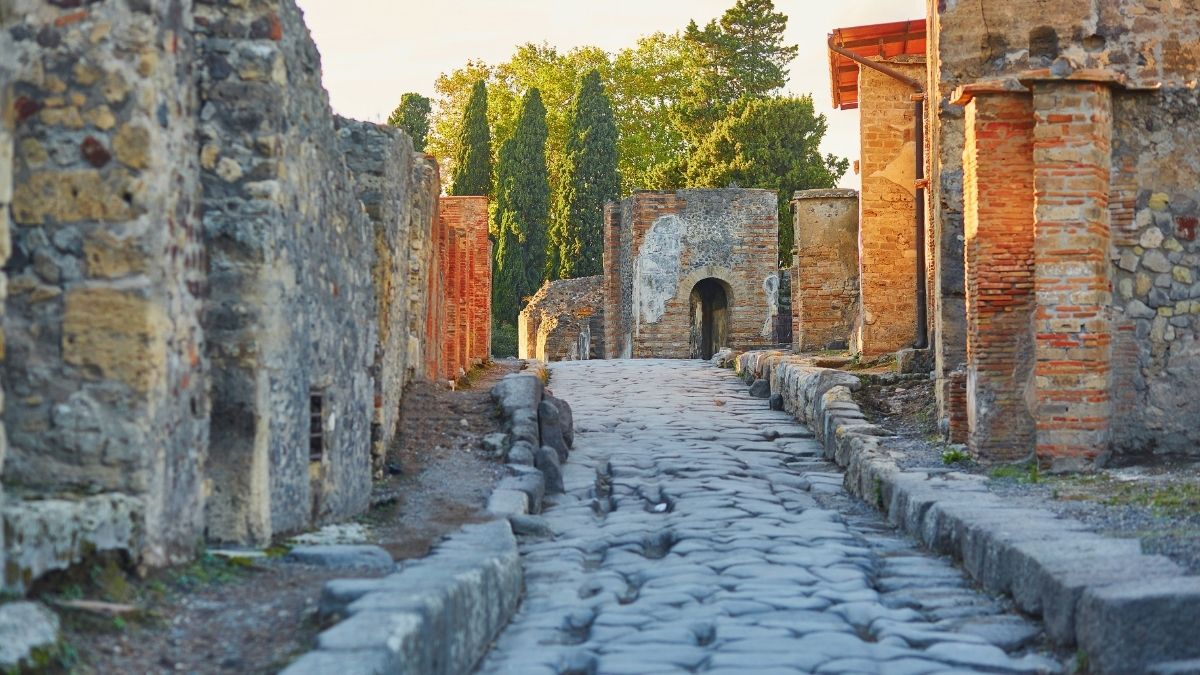 Antica strada lastricata di Pompei tra case romane, muri in pietra e mattoni