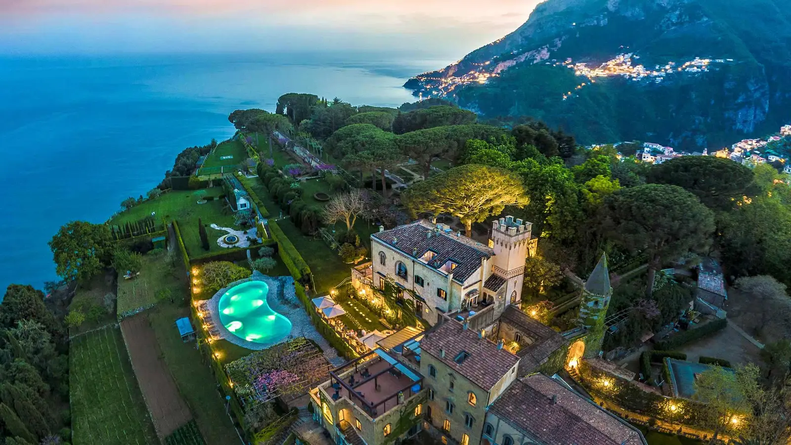Villa Cimbrone al crepuscolo con piscina illuminata e mare sullo sfondo